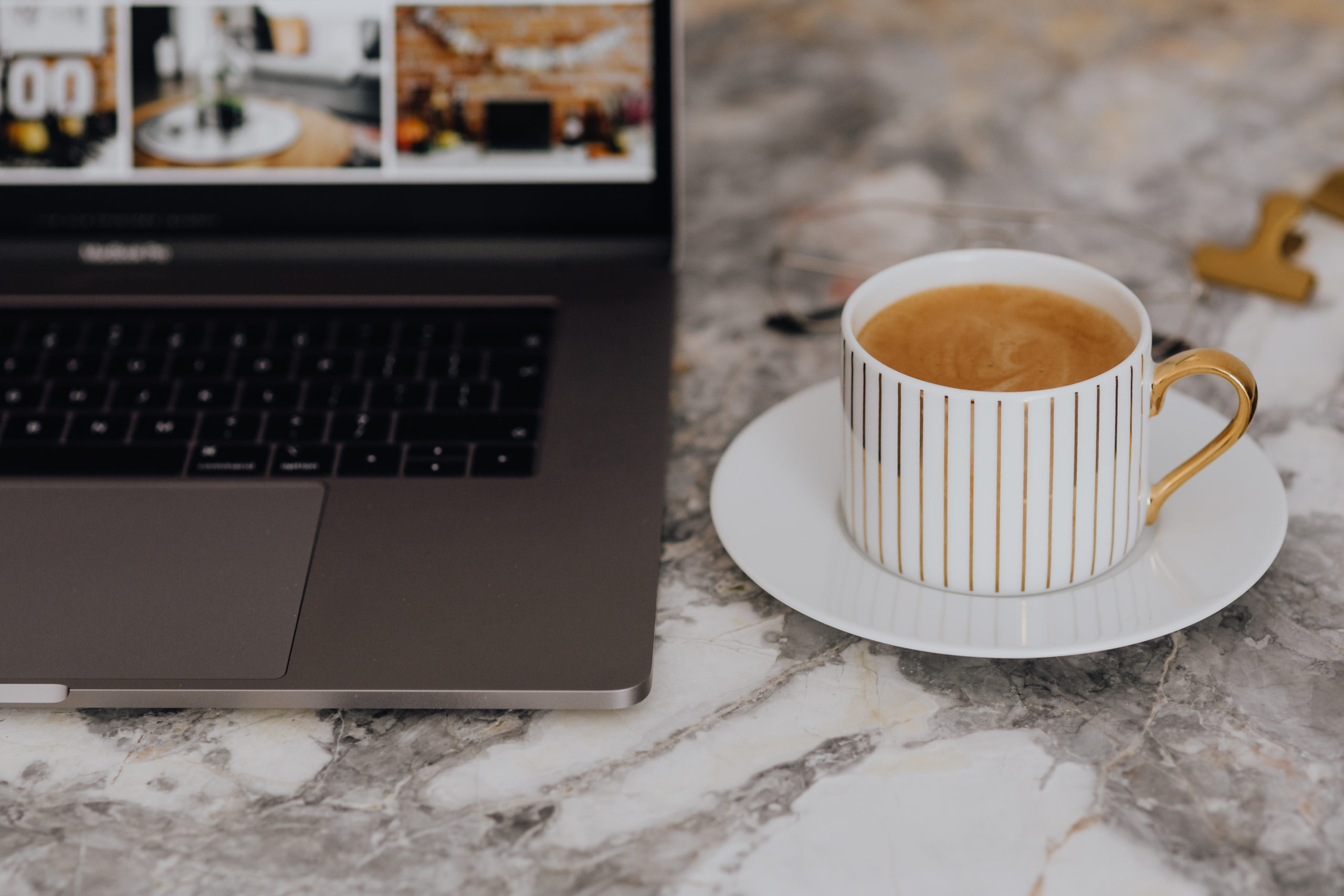 a white coffee mug on a marble desk with a laptop